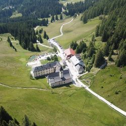 Drohnenaufnahme des Waldrast Natur Resorts mit Kloster und Kirche im Sommer